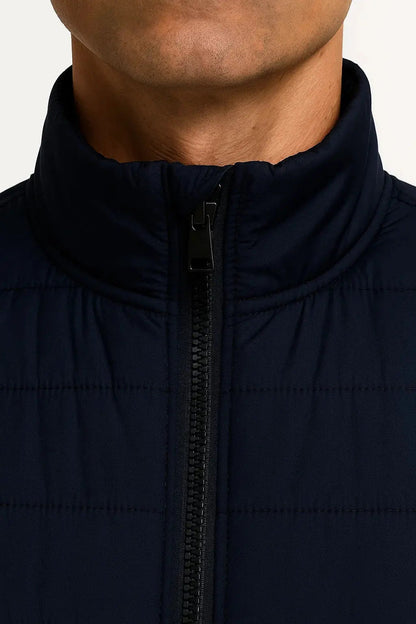 Close-up of men's navy blue lightweight quilted puffer vest featuring stand collar, front zip and padded insulation by ILYNORA