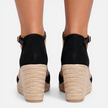 Back view of women's black closed toe espadrille wedges featuring adjustable ankle strap, jute wedge heel and suede finish by ILYNORA