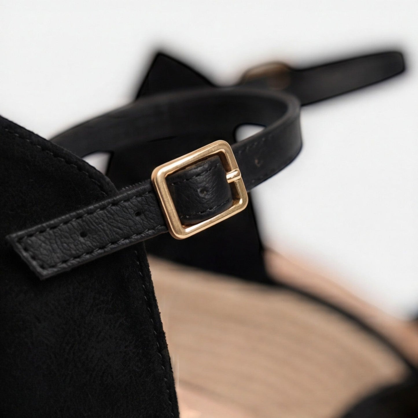 Close-up of women's black closed toe espadrille wedges with gold buckle, soft suede upper and woven jute wedge by ILYNORA