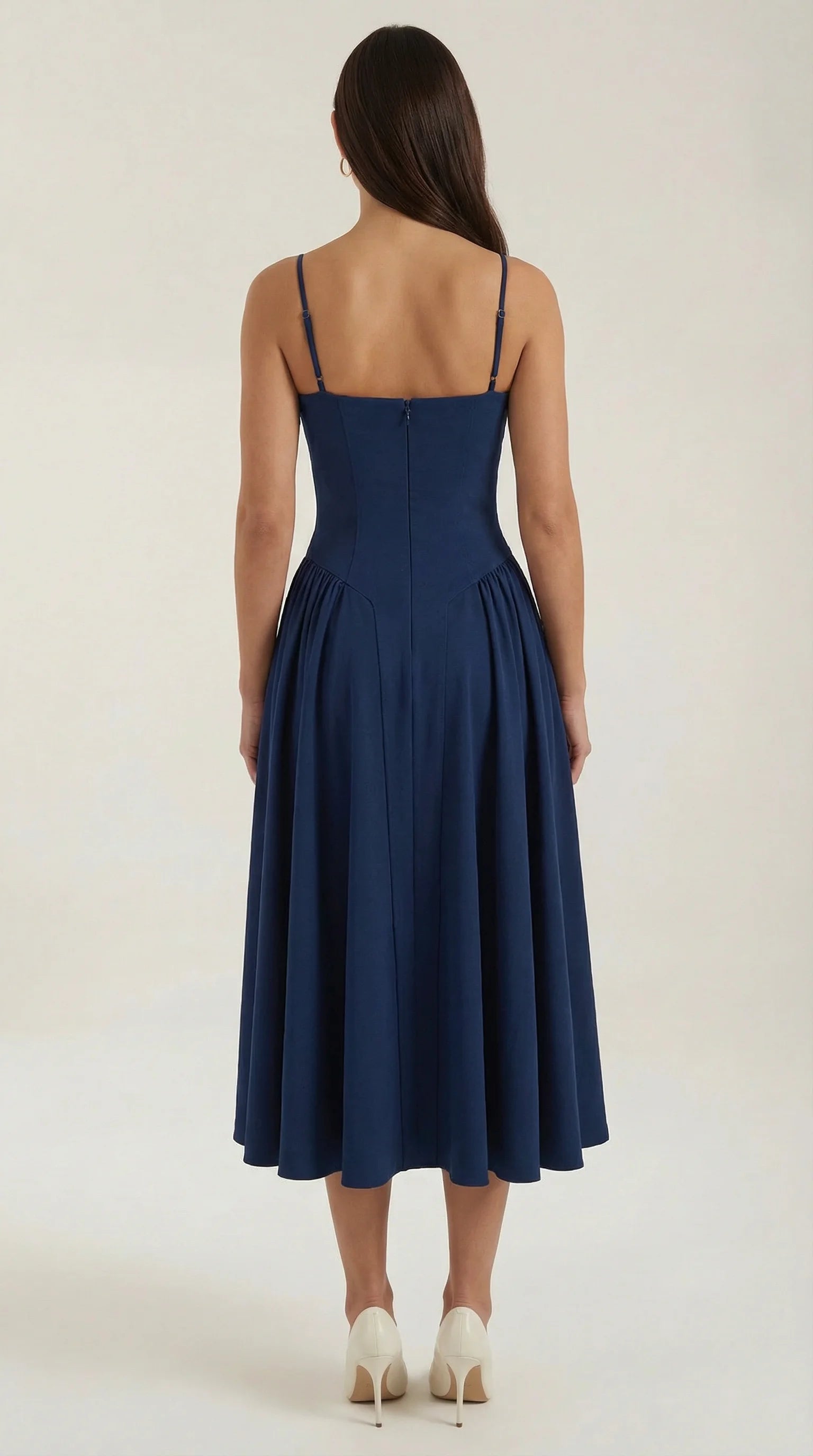 Back view of women's navy corset fit and flare midi dress with structured waist and flowing midi silhouette by ILYNORA