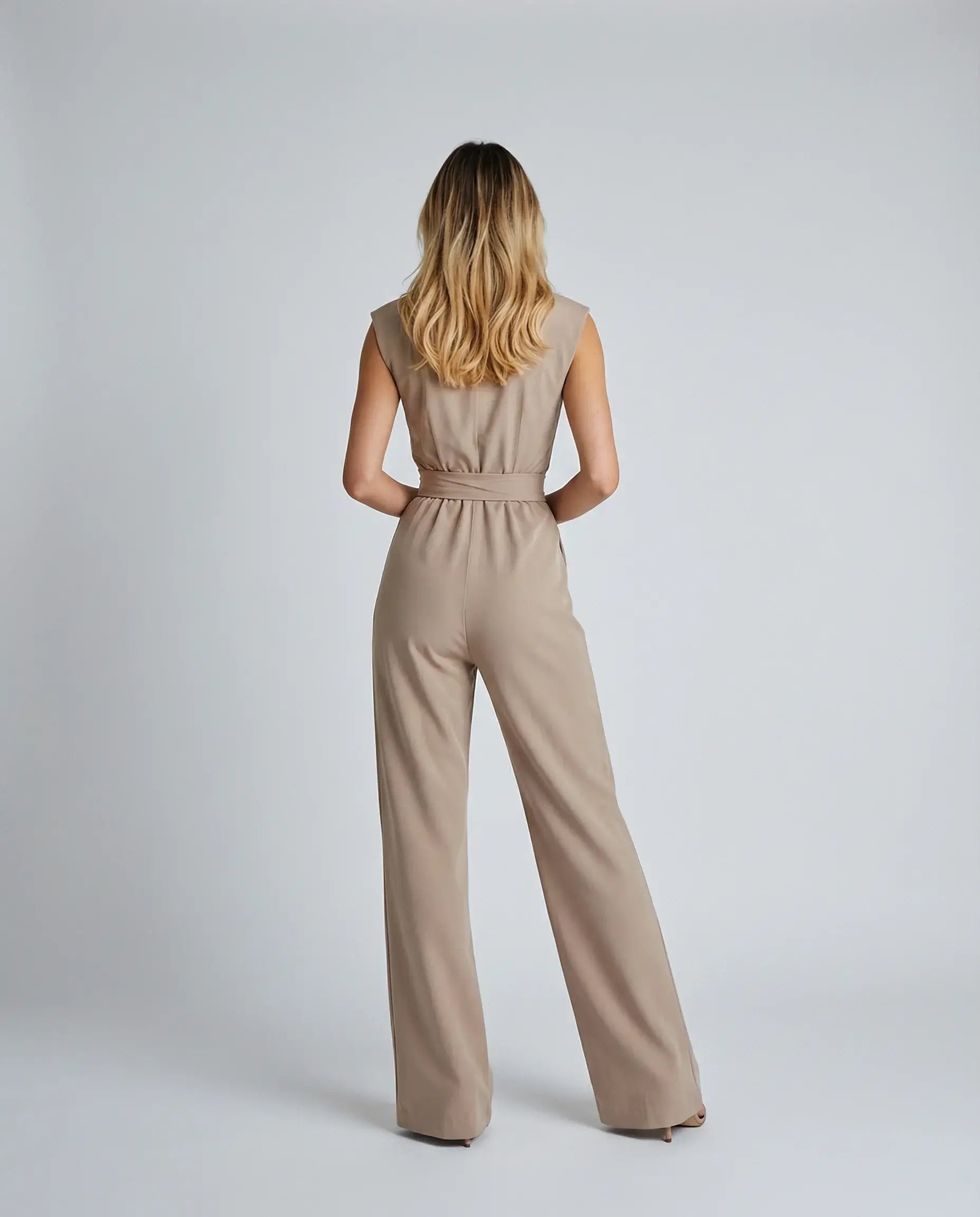 Beige sleeveless jumpsuit by Ilynora, side view with fluid movement and modern silhouette