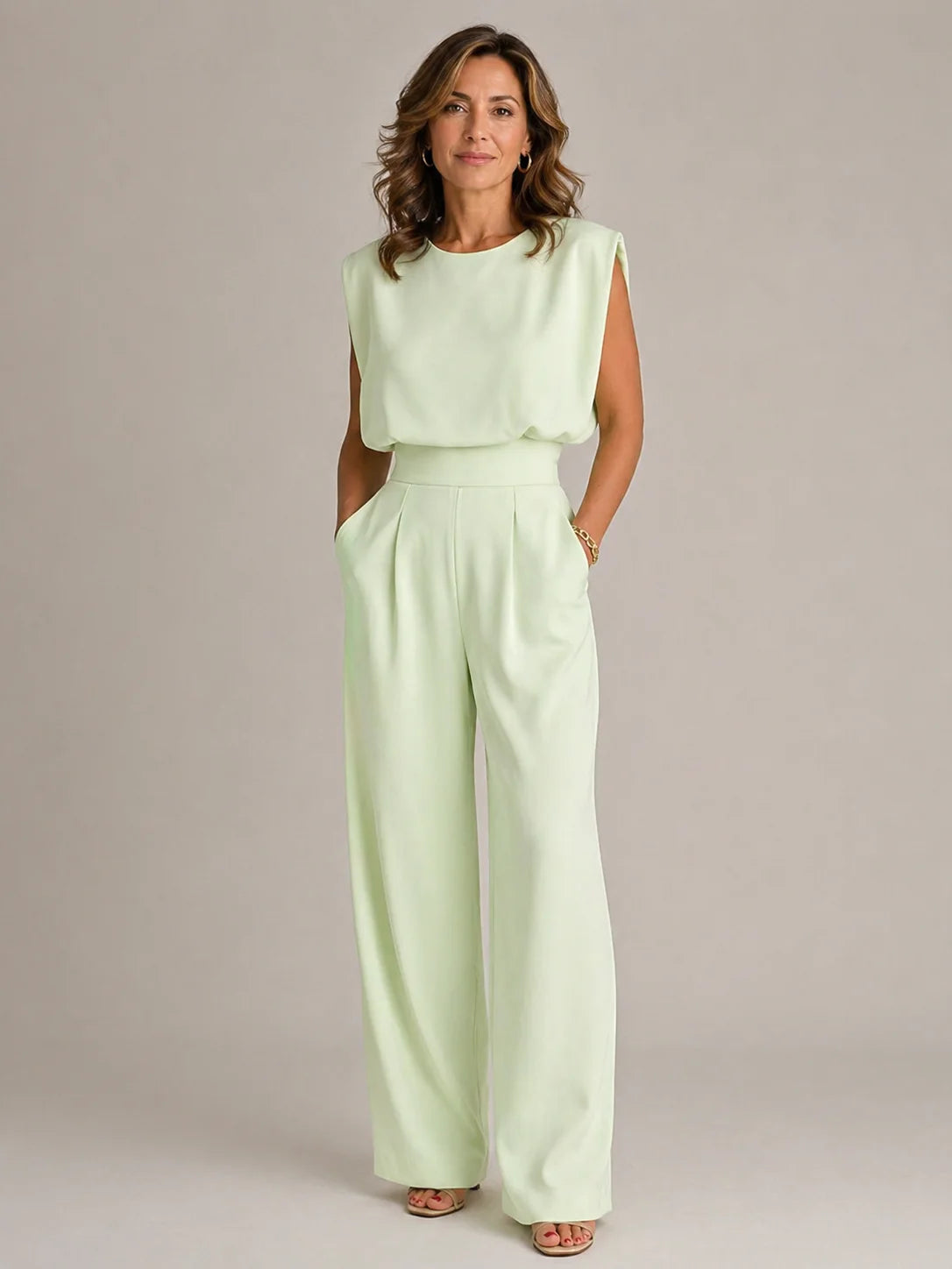 Women's green sleeveless pleated wide leg jumpsuit with draped bodice, high waist and elegant flowing full length trousers by ILYNORA