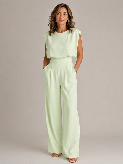 Women's green sleeveless pleated wide leg jumpsuit with draped bodice, high waist and elegant flowing full length trousers by ILYNORA