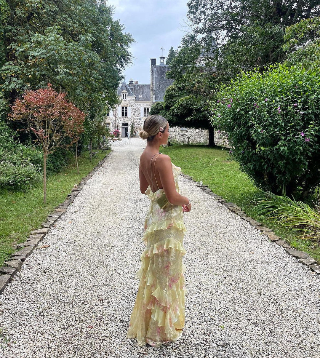 Women's yellow floral maxi dress by ILYNORA with cascading ruffles, slim straps and elegant open-back design